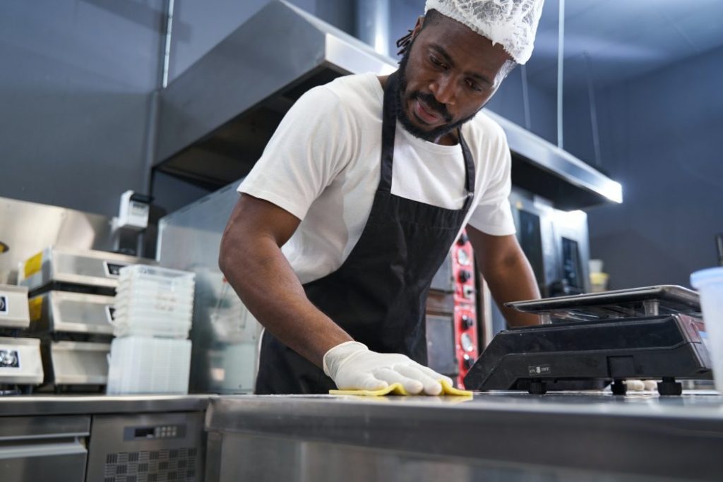 Chef working in restaurant and washing table